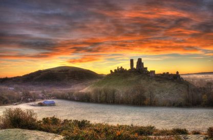 Castles in Dorset - ruins of Corfe Castle againt a sunrise