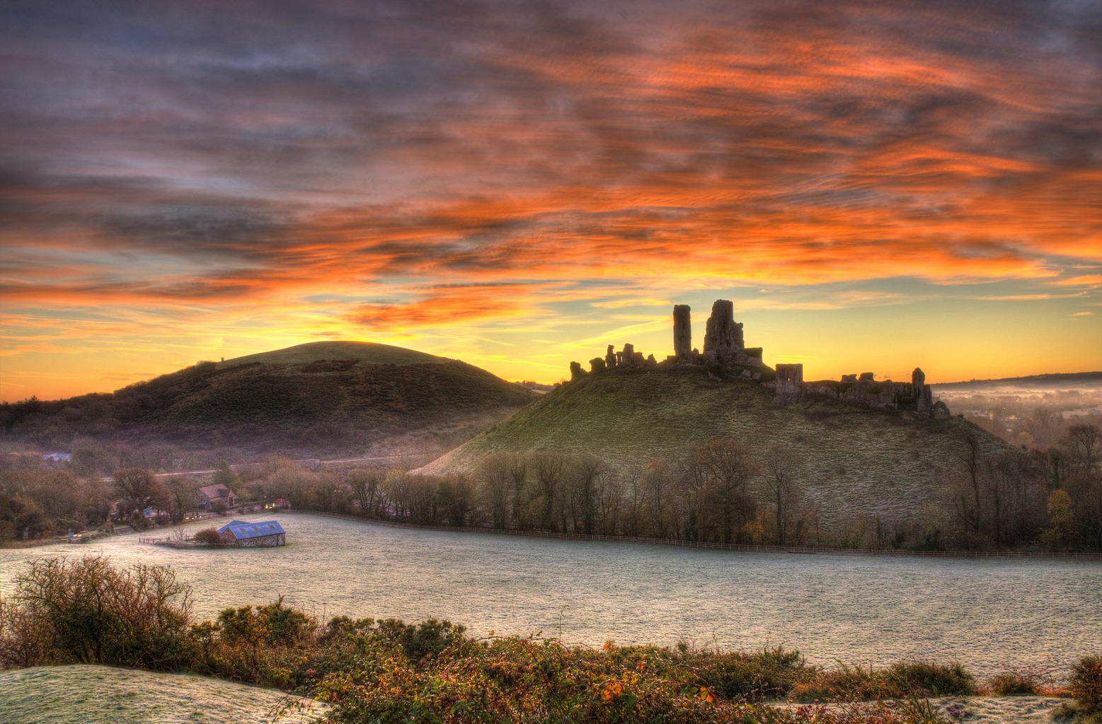 Castles in Dorset - ruins of Corfe Castle againt a sunrise