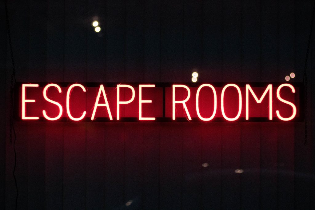 neon sign reading Escape rooms in yellow against a black background - Best Bournemouth Escape Rooms