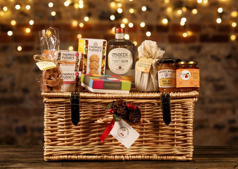 wicker hamper full of various food items and a bottle of conker gin