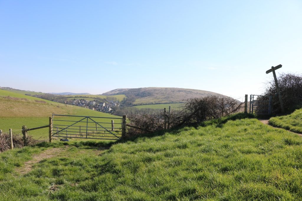 Gate and signpost in the countryside at Hambury Tout overlooking West Lulworth village