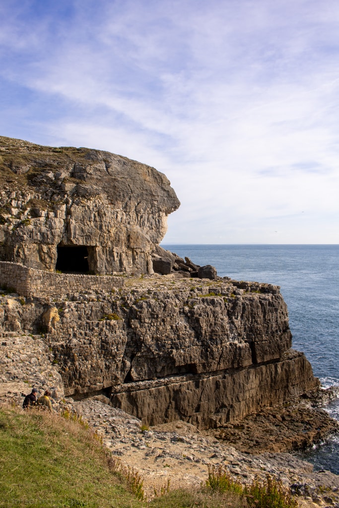 Square caves in a rock face above the sea on the walk to Dancing Ledge