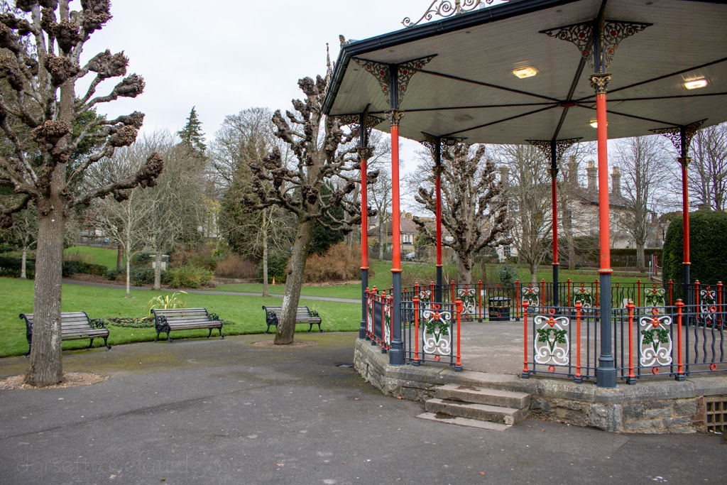 bandstand with red pillars nest to a walk path on an overcast day in borough gardens dorchester 