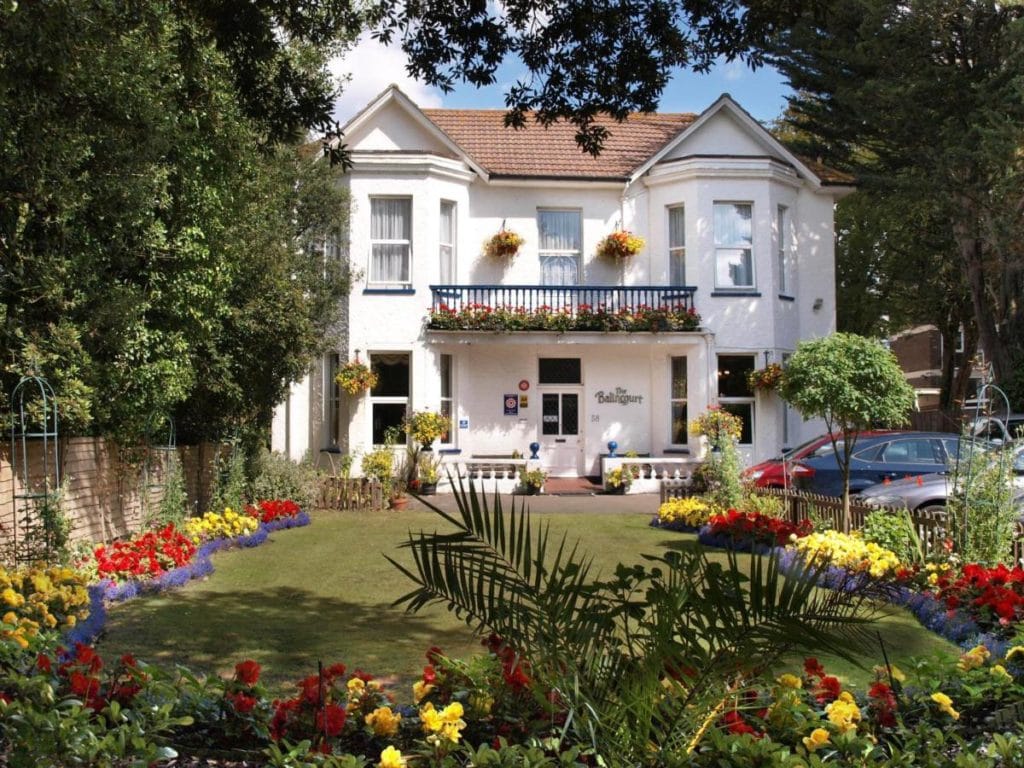 a large white manor house in a garden framed by green leafy trees - Balincourt is one of the most popular 5 star hotels in dorset