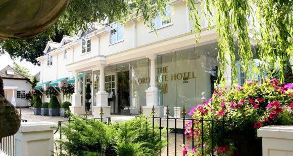 exterior of a large cream coloured hotel with floor to cieling glass between pillars on the ground floor. the sign reads lord bute hotel. 5 star hotels in dorset. 