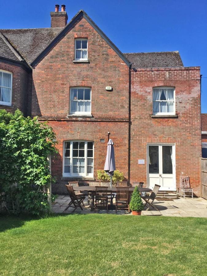 back of a 3 storey red brick townhouse with a neat lawn in front - best 5 star accommodation in dorset