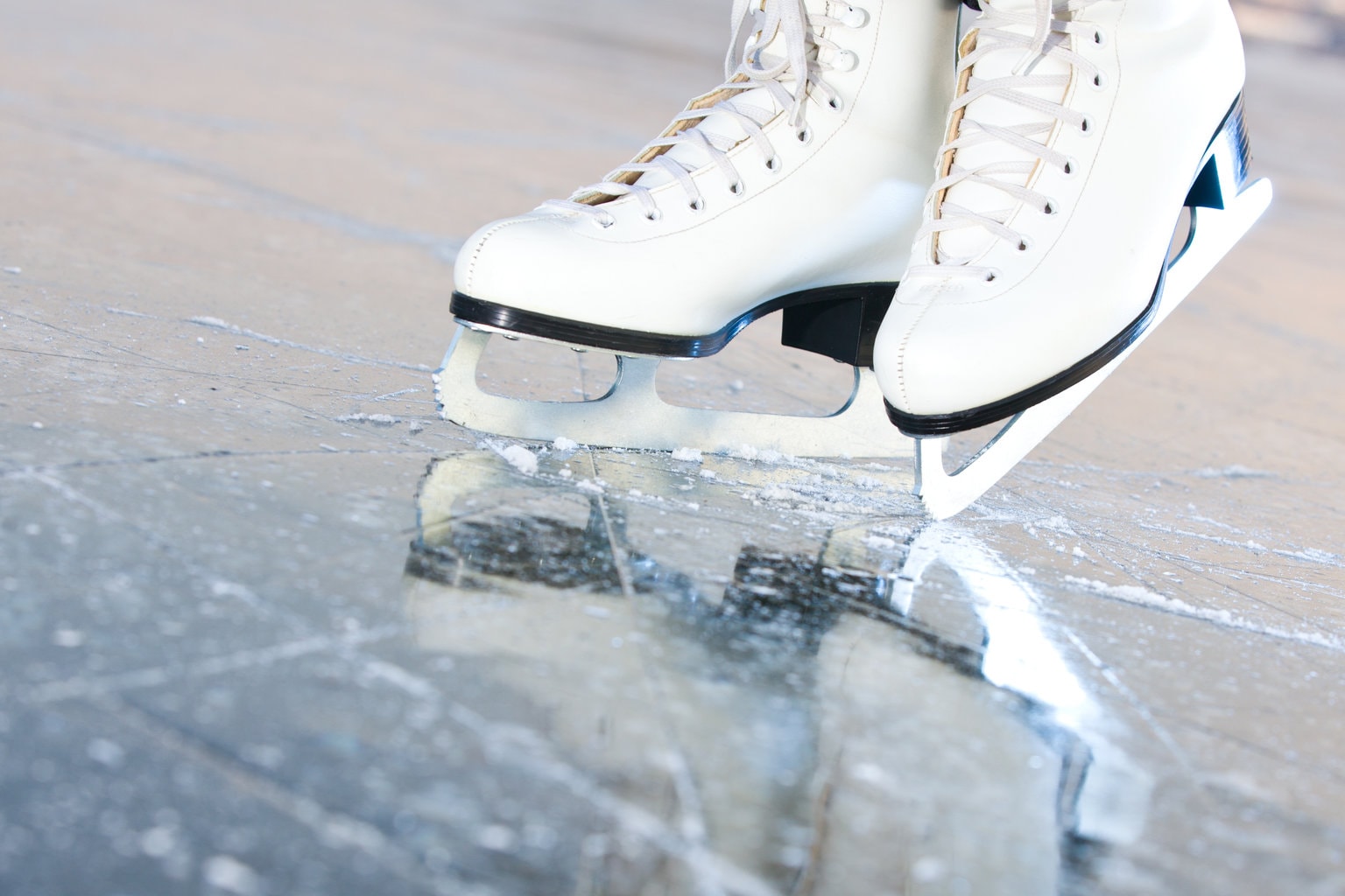 close up of white ice skates with laces on ice. Ice rinks in Bournemouth and Dorset. 