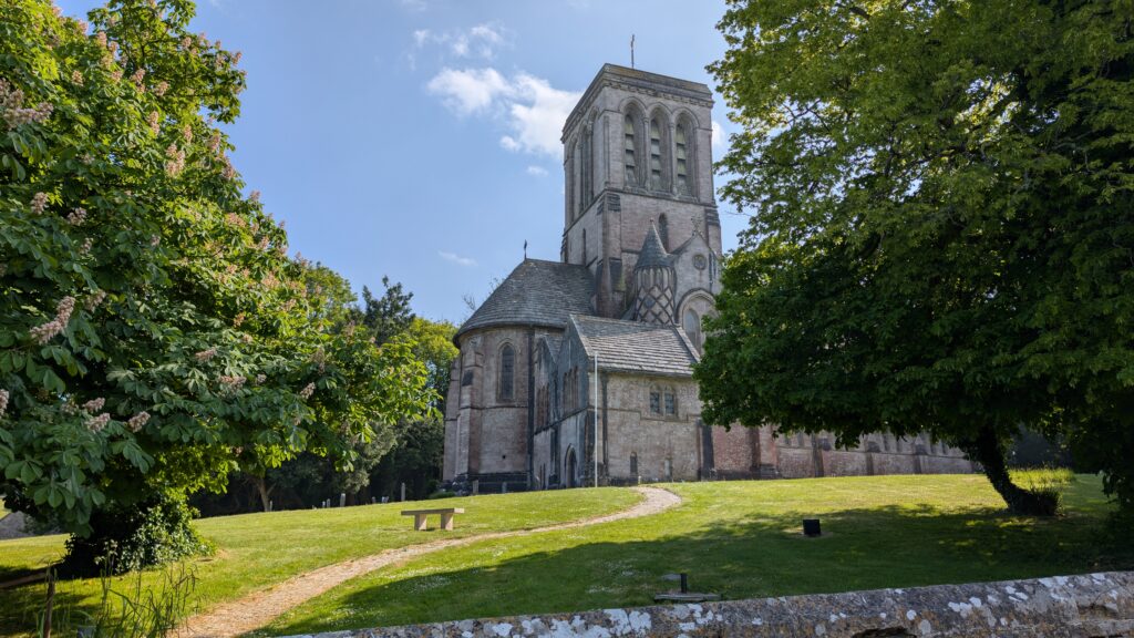 Large church with a grassy lawn in front surrounded by trees