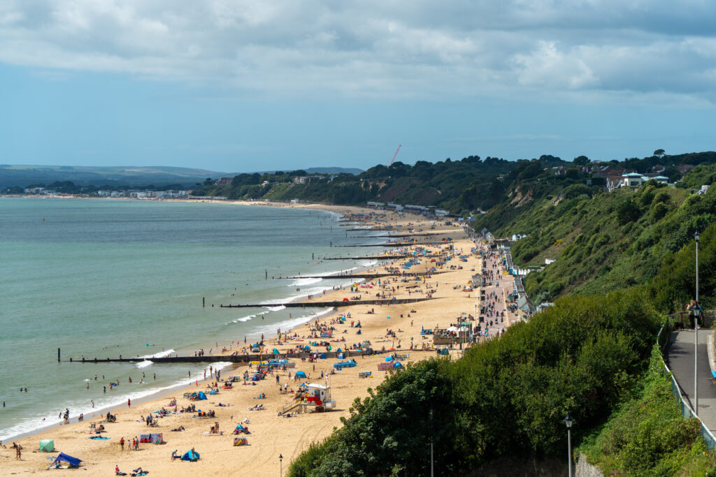 Long sandy beach line with stone groynes stretching into the sea