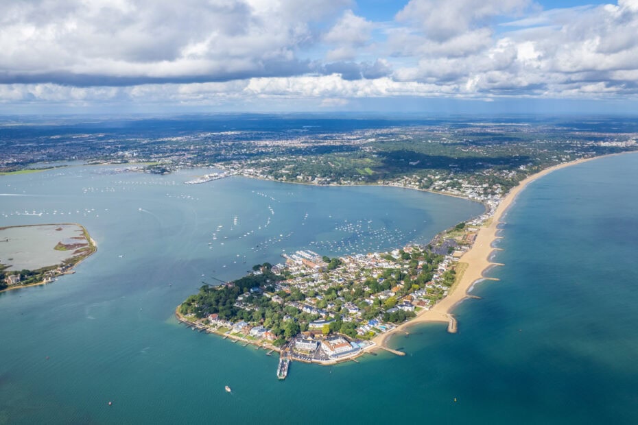 aerial panorama view of Sandbanks peninsula with a long white sandy beach along one side and blue sea on either side